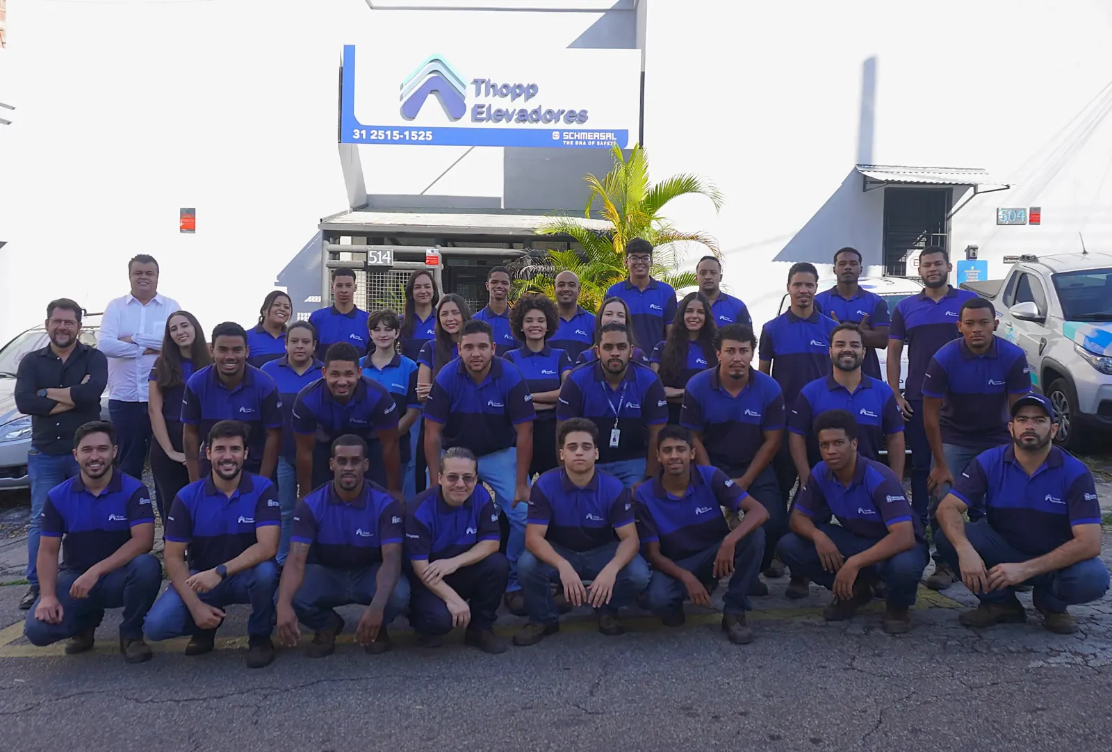 Equipe da Thopp Elevadores, com cerca de quarenta profissionais de uniforme azul, reunida em frente à sede na Rua Rio Espera, 514, em Belo Horizonte