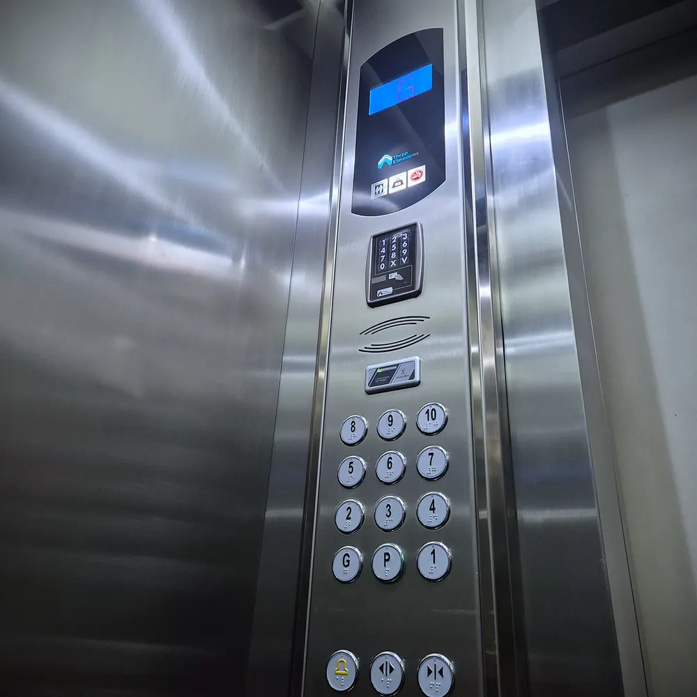 Cabine de elevador modernizada pela Thopp, com painel em aço inox escovado, indicador digital de andar, teclado do Thopp Code e botoeira nova com braile