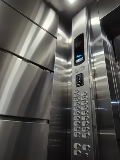Cabine de elevador modernizada pela Thopp, com revestimento em aço inox escovado, indicador digital de andar, botoeira nova e teclado do Thopp Code