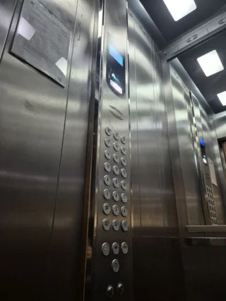 Painel de cabine em inox com coluna de botoeira e iluminação no teto