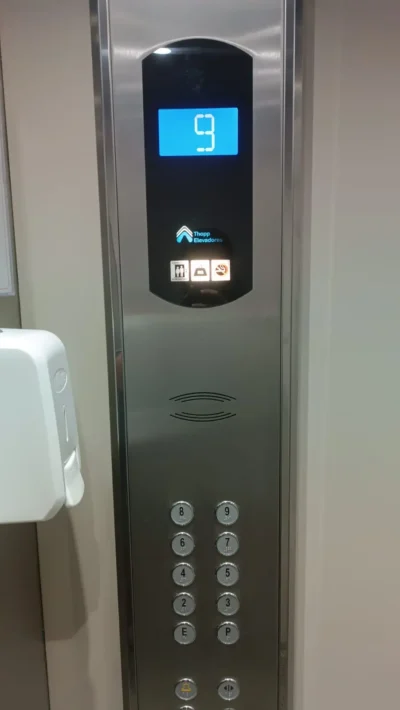 Coluna de botoeira de cabine em inox com display digital azul e botões com identificação em braile